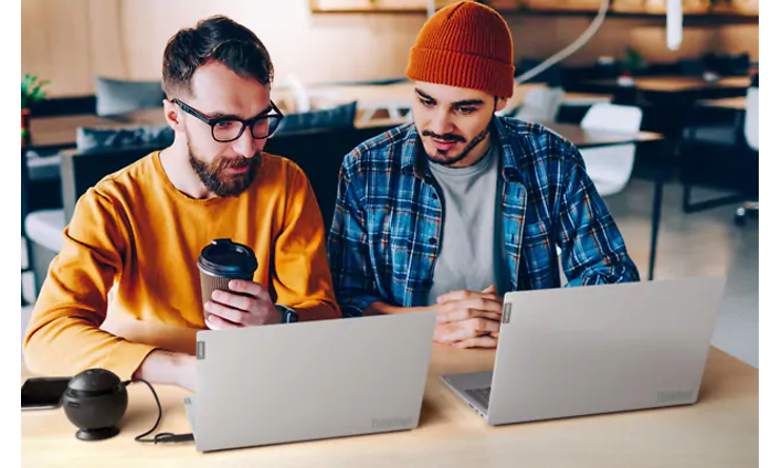 Kaksi miestä työskentelevät Lenovo ThinkBook -kannettaviensa parissa