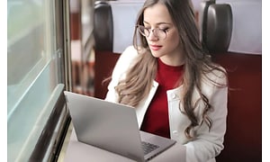 Nainen käyttää Lenovo ThinkBook -kannettavaa junamatkallaan