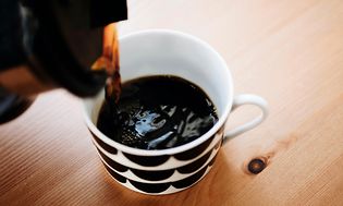 black brewed coffee being poured into a mug