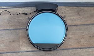 Musta robottiimuri latausasemaan kytkettynä