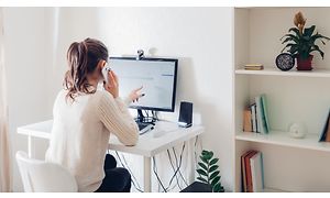 Woman working on a computer and talking on a phone - 3200x1800
