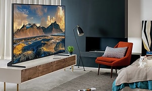 Modernissa olohuoneessa iso TV, jossa vuoristomaisemakuva